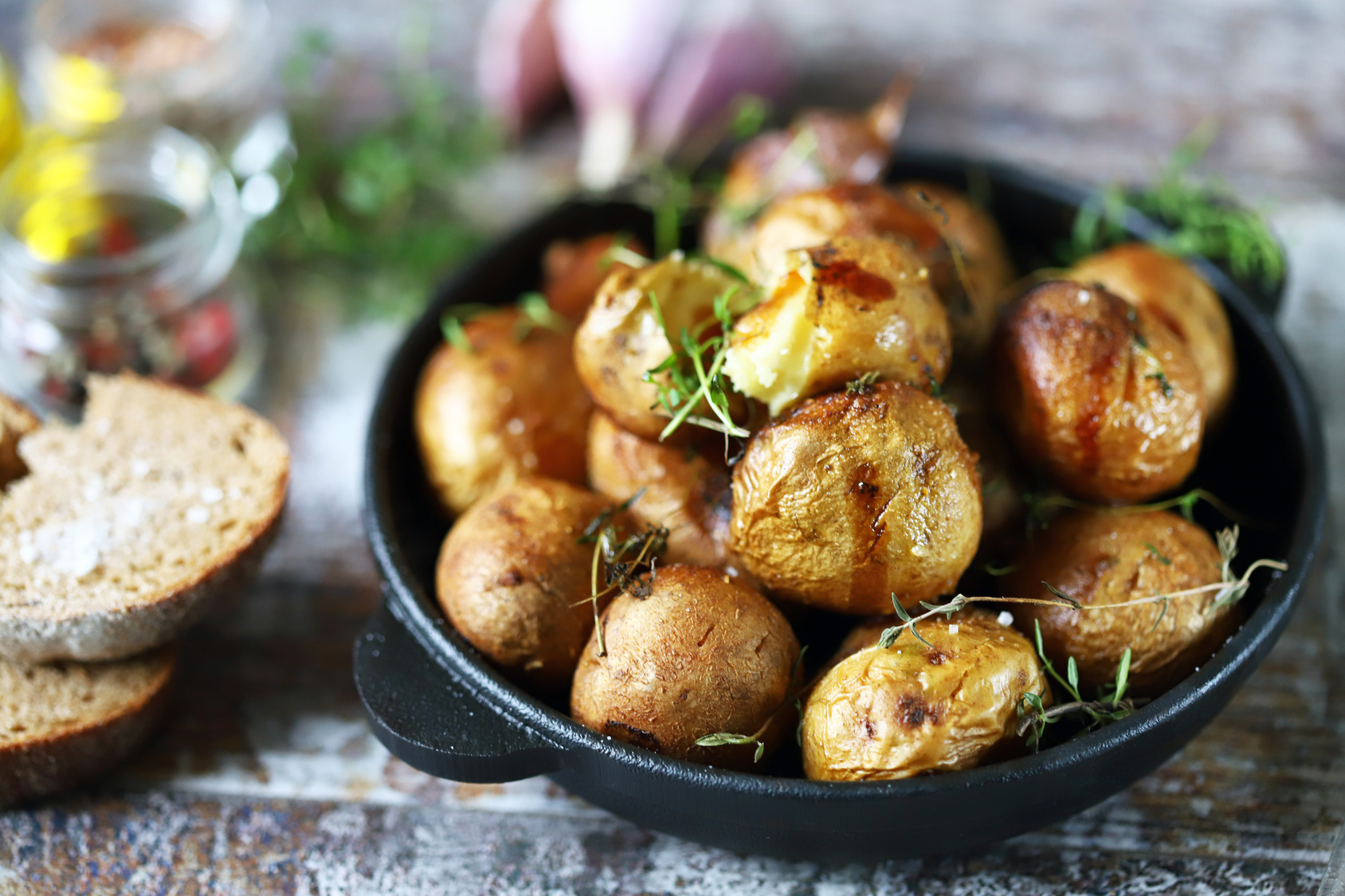 Illustrative stock photograph of skin-on baked potatoes in a cast-iron skillet